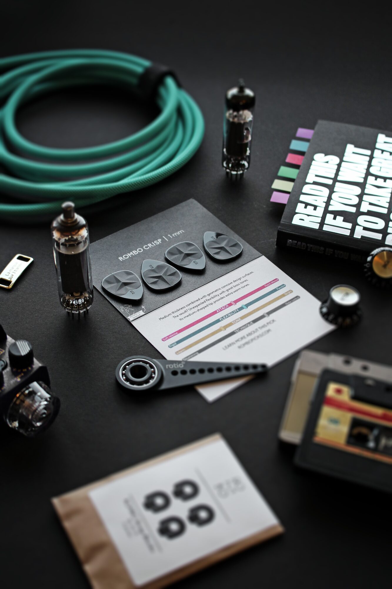 Vacuum tubes, patch cable and cassette laid out on black