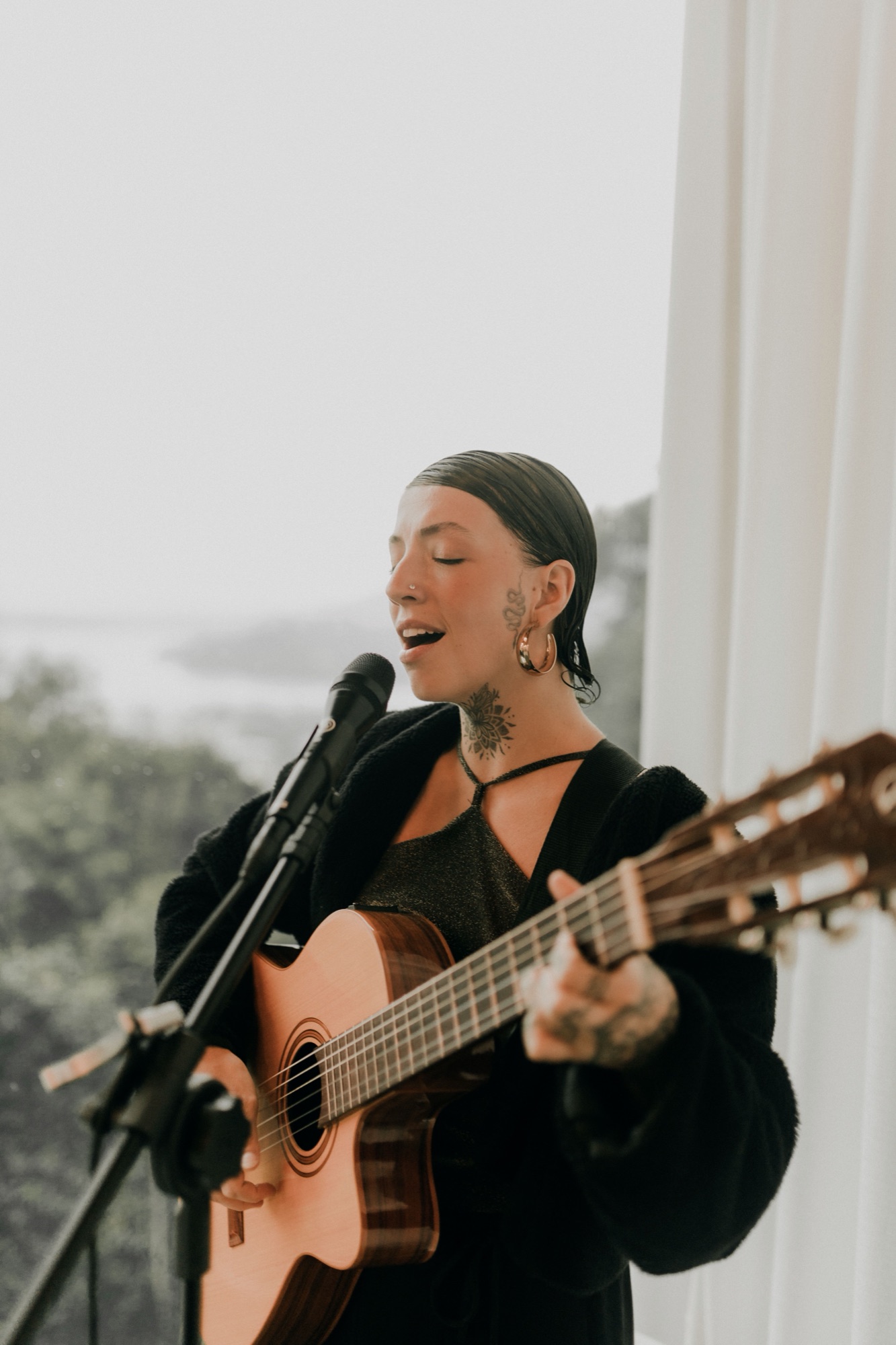 Singer with acoustic guitar at a microphone