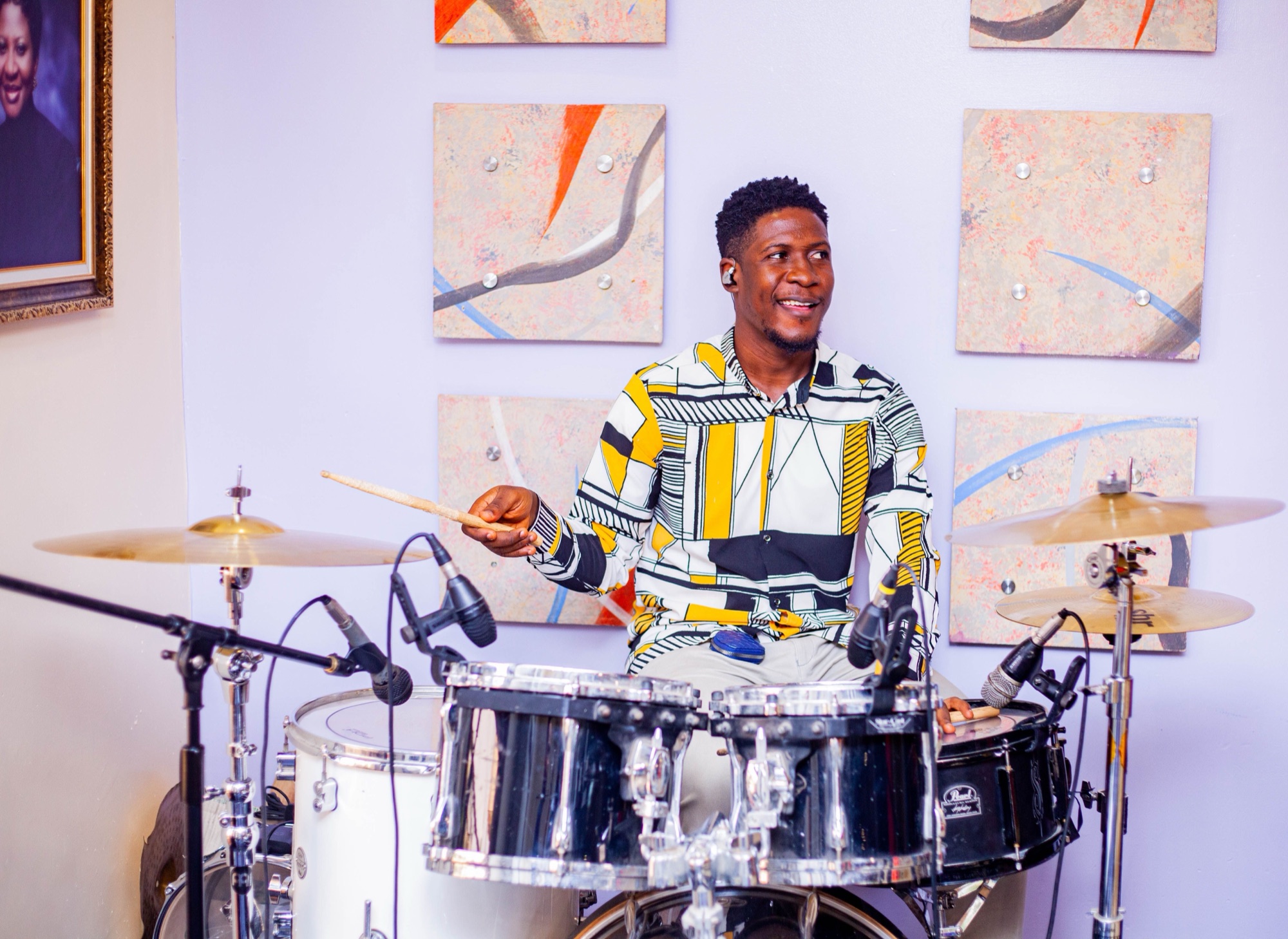 Drummer playing in a bright room
