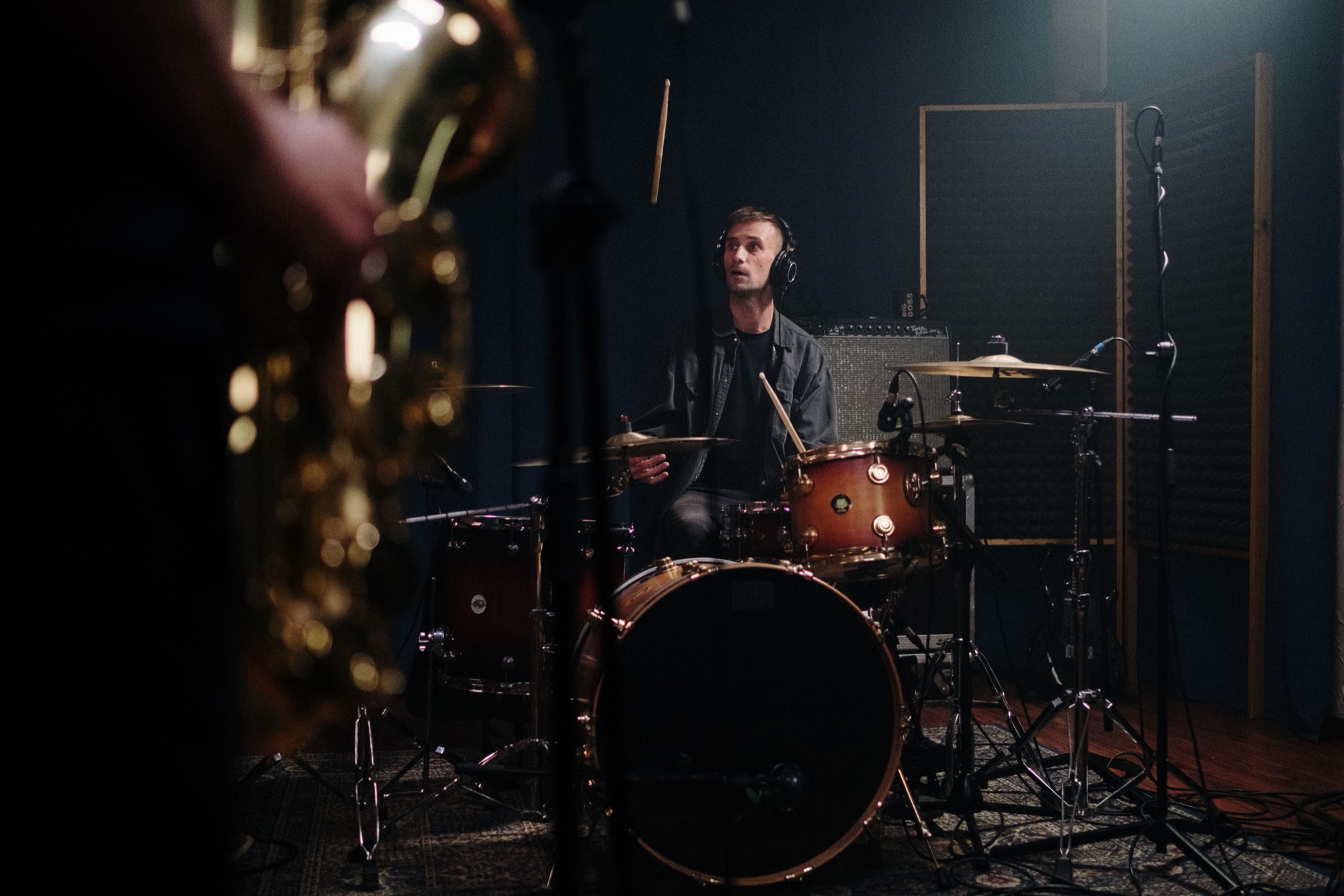 Drummer playing in a dark moody studio