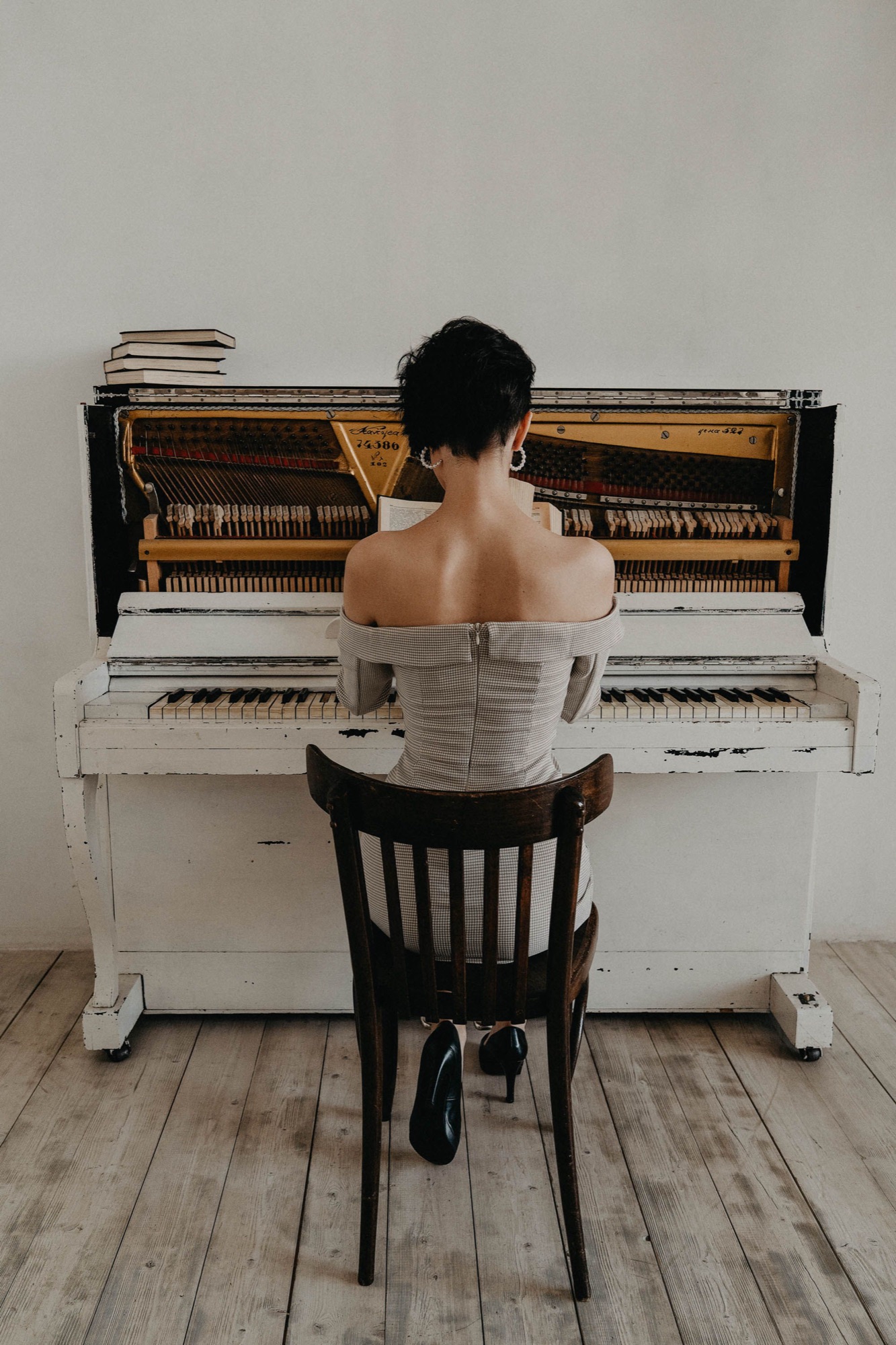 Woman at a white upright piano in a bright room