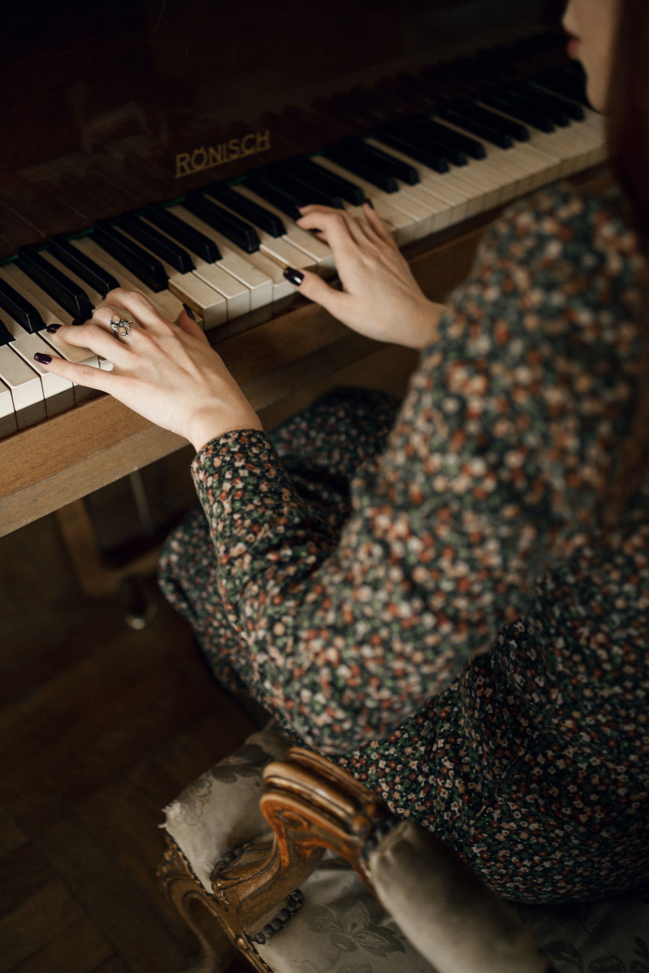Hands playing an old piano in dark light
