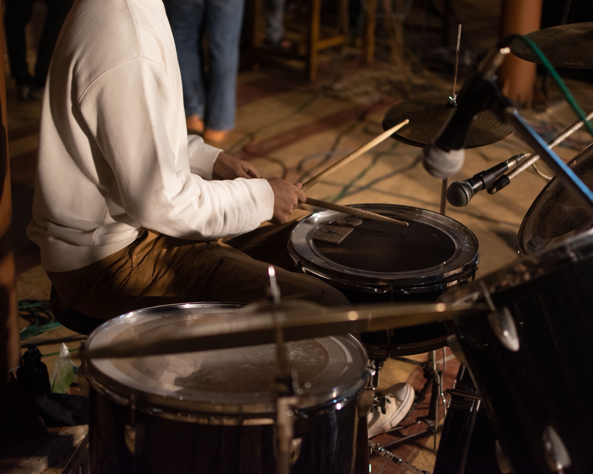 Drummer playing in warm club light